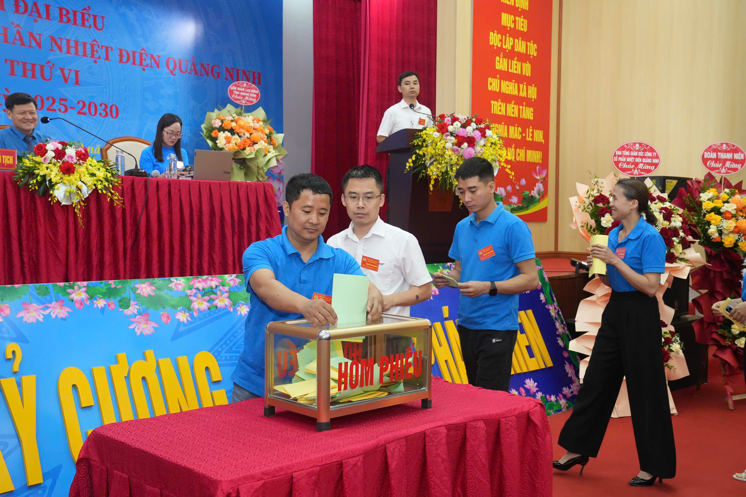 A group of people standing around a tableAI-generated content may be incorrect.