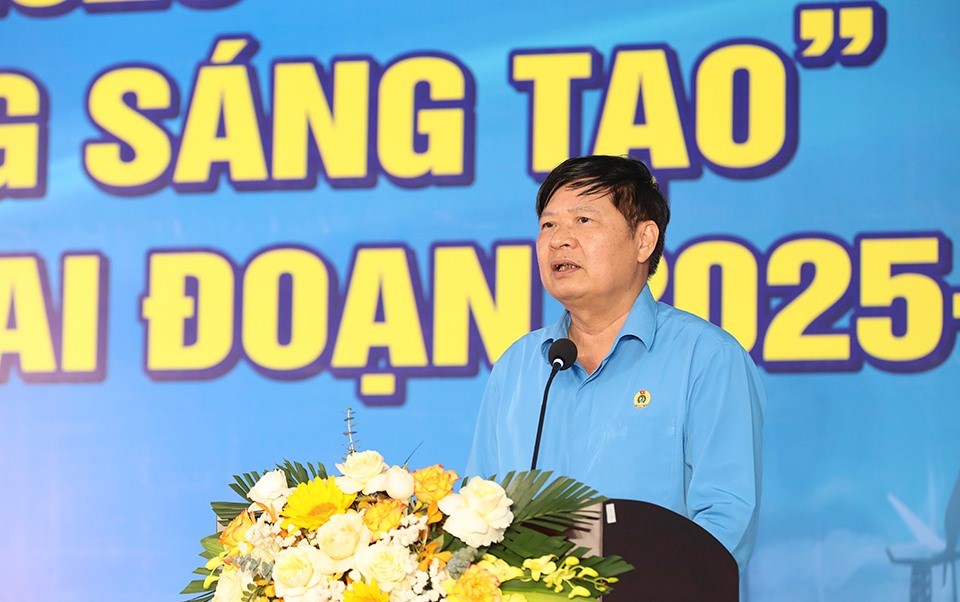A person standing at a podium with a microphone and flowersAI-generated content may be incorrect.