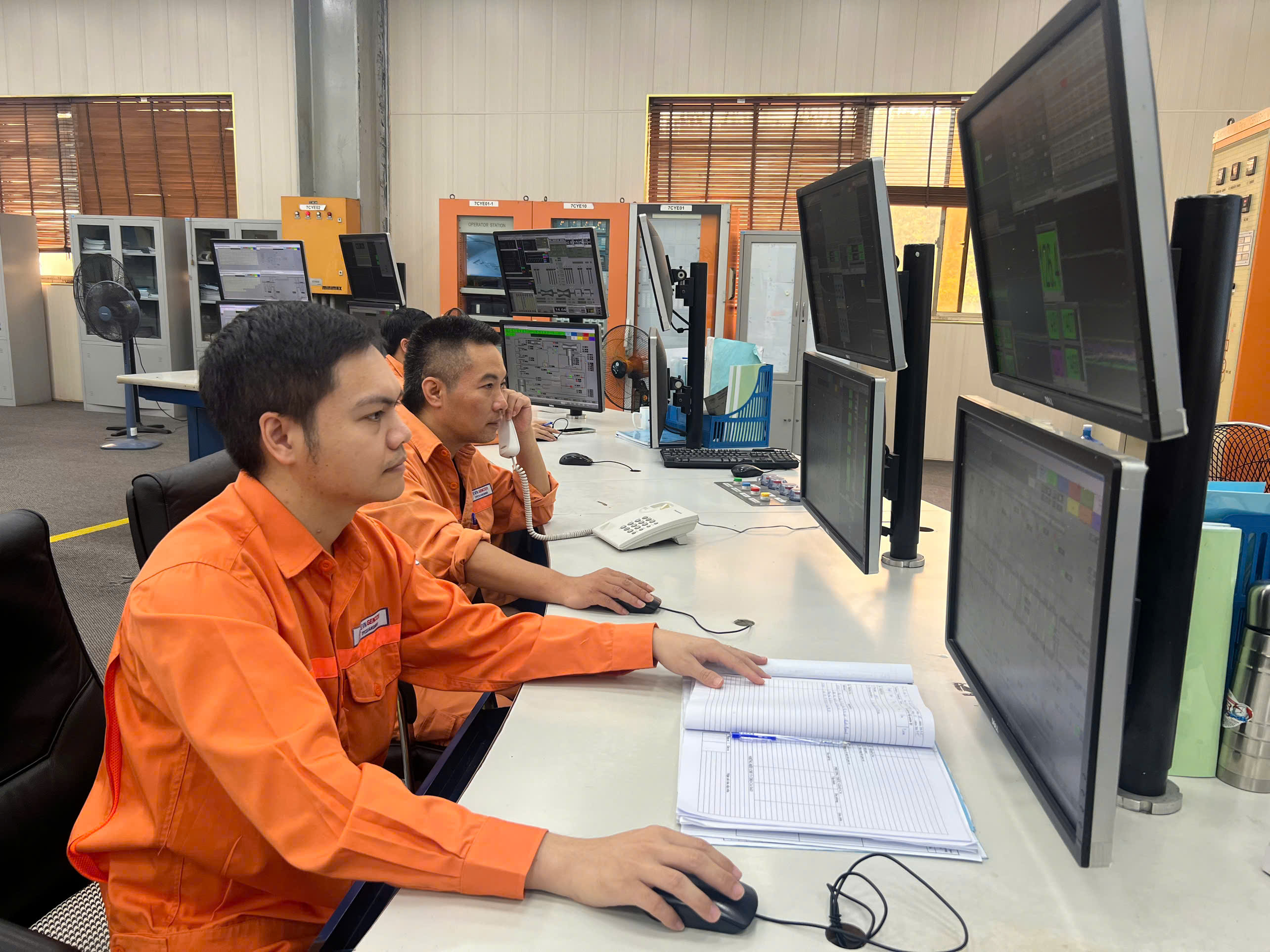 A group of men sitting at a desk with computersAI-generated content may be incorrect.